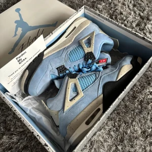 Nike Air Jordans 4  i ljusblå mocka - Snygga Nike Air Jordans i ljusblå mocka med svarta och grå detaljer. Skorna har snörning och en unik design med nummer 23 på plösen. Väldigt bra skick 10/10 använt dem max 10 gånger. Köpte dem för 6500 ny. Perfekt sko inför våren/hösten 