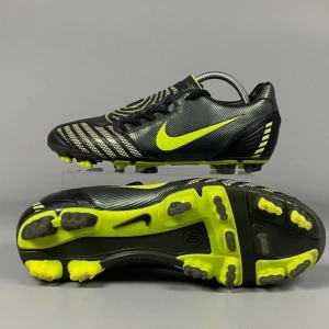 Nike Total 90 Shoot II FG 2007 – Size 41 -  Vintage och sällsynta Nike Total 90 Shoot II från 2007, i mycket bra skick. Klassisk svart och grön design med fokus på precision, kraft och kontroll på planen. Perfekta för fasta underlag – stabila och komfortabla. Ett eftertraktat samlarobjekt för fotbollsälskare och proffsspelare!