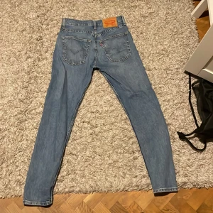 Levis 512 jeans i ljusblå denim. Aldrig användt bara legat i garderoben.  - Snygga Levis 512 jeans i ljusblå denim med klassisk femficksdesign. De har en dragkedja och knapp framtill samt den ikoniska Levis-lappen på baksidan. Perfekta för en avslappnad stil.