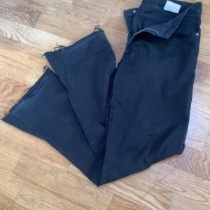 Svarta jeans med fransar - Snygga svarta jeans med fransar vid bensluten. De har en klassisk femficksdesign och knappar i midjan. Perfekta för en avslappnad stil finns ingen skador men jag har använda den typ tre månader sen jag tänkte sälja den om någon är intresserad 🙏