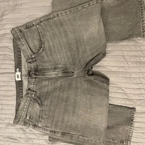 Grå jeans från 157 - Säljer ett par grå jeans från 157. De har en klassisk femficksdesign och stängs med dragkedja och knapp. Perfekta för en avslappnad stil. Köpt:400kr