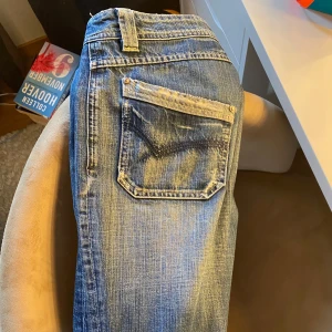 Blå jeans med slitningar - Snygga blå jeans med coola slitningar och en klassisk femficksdesign. De har en dragkedja och knapp framtill. Köpta här på plick för några veckor sedan och tyvärr är dom lite för små för mig💔verkligen super snygga på och är kär i dem, mått på sista sliden, skriv om frågor❤️