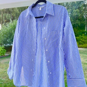 Randig skjorta - En blå/vit-randig oversized skjorta i storlek XS. Oversized på mig som normalt har S. Inköpt för flera år sedan men blev bara liggandes i garderoben, därför väljer jag nu att sälja den 💕  (ALDRIG ANVÄND!)  Längd: 81 cm Axel: 54 cm