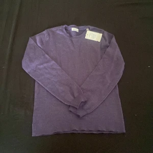 Lila merinoulltröja från Stenströms - Säljer en superfin lila tröja från Stenströms i 100% merinoull. Den är i nyskick och har en klassisk design med rund hals och långa ärmar. Perfekt för både höst och vinter, och den är riktigt mjuk och skön att ha på sig. Passar perfekt för en stilren look!