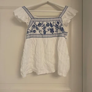 Vit blus med brodyr💕 - Blus/ topp med brodyr💞 Knytdetalj i ryggen💕  Saknas lapp så vet inte med säkerhet storlek eller märke då jag köpte secondhand💓 Uppskattningsvis XS/S