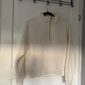 Vit fleece tröja med dragkedja - Säljer en supermysig vit fleece tröja med halv dragkedja. Perfekt för kyliga dagar när du vill hålla dig varm och bekväm. Tröjan har en hög krage och långa ärmar, vilket gör den idealisk för både höst och vinter. Den är i bra skick och redo för nya äventyr!