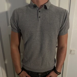 Grå Massimo Dutti Finstickad Pikétröja - Stilren Grå Massimo Dutti Polo Pikétröja 100% Extra Fint Bomull i grymt skick! Storlek M men passar även som S. Modellen är 182 cm och väger 75 kg. Pris går att diskuteras!