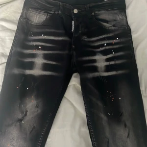Svarta jeans från Dsquared2 - Hej! Säljer ett par svarta limited edition Squid Game jeans från Dsquared2, köpta 2021 men bara använda några fåtal gånger då dom inte passade så bra. Storlek 42, ja dom är äkta men säljer för lågt pris då ja vill bli av med dom! priset kan gå ner till 2000kr.