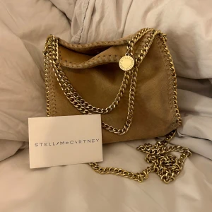 Stella McCartney väska - Säljer denna otroligt fina väska från stella McCartney som tyvärr inte kommer till användning. Är lite smutsig på tyget och tappat lite färg på en liten del av kedjan, där av priset. Köpt här på plick. Följer med kort till väskan. 💗💗orginal pris 8200