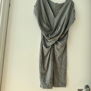 Klänning  - Letar du efter det ultimata statement-plagget för ditt nästa evenemang? Sök inte längre! Vår ärmlösa, rygglösa festklänning utstrålar elegans och sofistikering. Med sin eleganta design och smickrande silhuett är denna klänning perfekt för att göra en