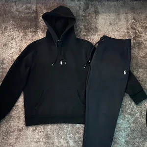 Svart hoodie och byxor från Ralph Lauren - Säljer en stilren svart hoodie samt byxor från Ralph Lauren med det klassiska logotypbroderiet.  En riktigt fin tracksuit. 