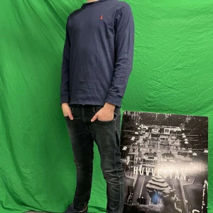 Ralph lauren tröja - Säljer en stilren mörkblå långärmad tröja från Ralph Lauren med det klassiska röda logotypen på bröstet. Perfekt för en avslappnad och snygg look. Lappen i nacken är trasig 