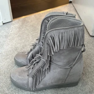 Grå boots med fransar - Snygga grå boots i mocka med fransdetaljer. De har snörning framtill och en bekväm sula. Perfekta för en trendig look.