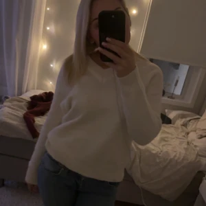 Vit stickad tröja - Mysig vit stickad tröja med v-ringning och långa ärmar. Perfekt för kyligare dagar och enkel att matcha med olika outfits.