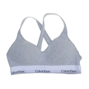 Grå bh från Calvin Klein - Säljer en grå bh från Calvin Klein med korsade axelband och elastiskt band med logotyp. Bh:n är köpt från Sellpy och säljs vidare då den tyvärr inte passade. Bra skick!