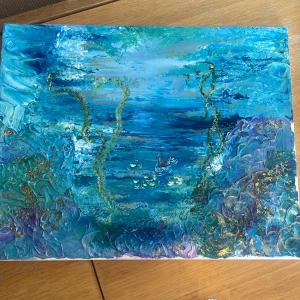 Abstrakt havsmålning i blått och grönt - En vacker abstrakt målning med havstema i olika nyanser av blått och grönt. Tavlan har inslag av guld och skildrar en undervattensvärld med växter och fiskar. Perfekt för att ge en känsla av lugn och djup till vilket rum som helst.