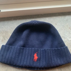 Mörkblå mössa från Polo Ralph Lauren - Tjena! Säljer denna Ralph Lauren mössa som används varsamt. Den har inga skador och är i fint skick. Skriv om du undrar något!😀