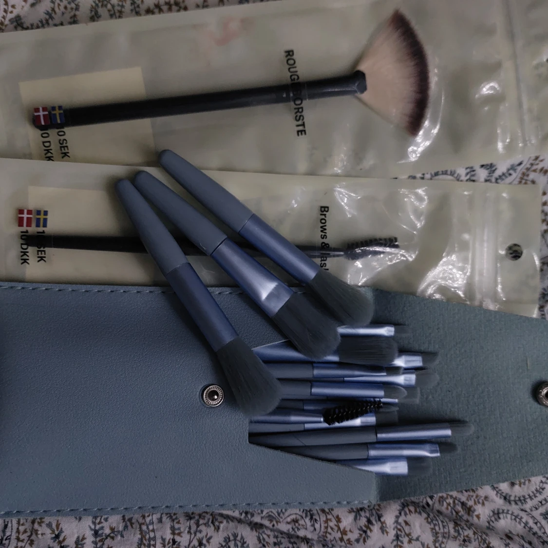 Set med sminkborstar i blått fodral