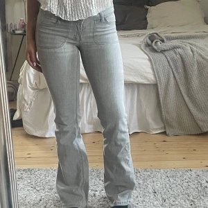 Grå bootcut jeans - Snygga grå lågmidjade bootcut jeans från Nelly men snygga detaljer på bakfickorna🤩de är storlek 34 men passar mig som är mellan 34-36!
