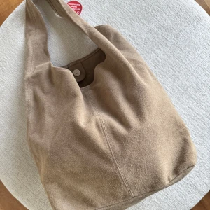 Väska mocka beige - Mockaväska liknar becksöndergaard, lite mindre. Köpt på amazon, returen var dyr, provar sälja. Äkta mocka. Ungefär 35-40 cm bred. Etikett kvar