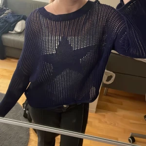 Y2k Mörkblå stickad tröja med stjärna - Säljer en mörkblå stickad tröja med stjärnmönster på framsidan. Inga defekter med tröjan och sparsamt använd. Den är genomskinlig och ger en trendig och Y2k look!