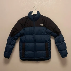 Blå och svart dunjacka från The North Face - Säljer min fina dunjacka från The North Face! Enbart använd till och från skola/jobb. Inga skavanker eller smutsfläckar, som ny! Nypris på Intersport 3599kr Mitt pris: 2000kr eller bud med rätt att neka.  Storlek S Herr (passar även 163cm lång tjej med en lätt ”oversized fit”)