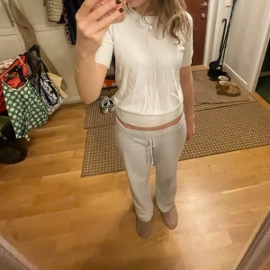 Vit kortärmad topp - Säljer en vit kortärmad topp med rund hals. Perfekt för en avslappnad stil. Passar bra till både jeans och mjukisbyxor.