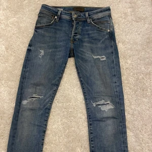 JJ jeans med slitningar - Säljer ett par blåa jack and Jones jeans med unika slitnigar i storleken w28xl30 