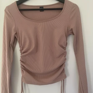 Rosa ribbad topp - Säljer en beige ribbad topp från shein med långa ärmar och snygg knytning på sidorna. Toppen är lite rundad i halsen. I storlek S men sitter jätte bra på en med xs också. Använd några enstaka gånger men i väldigt bra skick.
