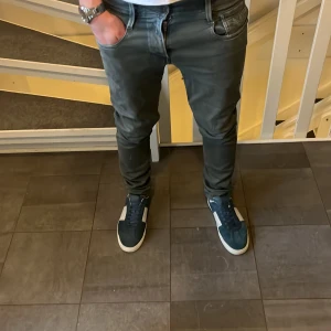 Grå jeans från Replay Anbass - Snygga grå jeans från Replay Anbass med en modern slim passform. Byxorna har en klassisk femficksdesign och dragkedja. Perfekta för en stilren look.