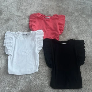 3pack sommartoppar med volangärmar från Zara - Säljer tre snygga toppar från Zara i svart, vit och coral rosa. De har korta volangärmar och är ribbade, kommer passa perfekt i sommar!☀️👌Kontakta mig vid intresse av endast en av tröjorna så ska vi fixa det🤝💞Säljer isåfall 35kr/st