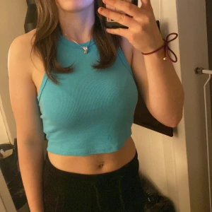 Turkos ribbad linnetopp - Säljer en snygg turkos ribbad linnetopp från New yorker. Toppen är ärmlös och croppad i storlek L men det är som en S/M.🏖️☀️
