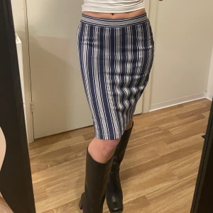 Randig kjol från Bondelid - Snygg randig kjol från Bondelid i blått och vitt. Kjolen har en tight passform och är perfekt för en stilren look. Den är knälång och har ett klassiskt mönster som ger en tidlös känsla.