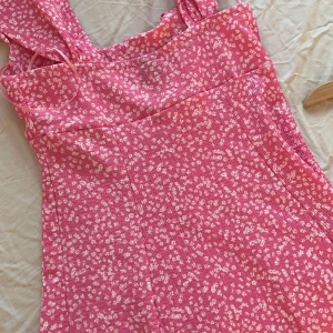 Rosa blommig klänning från Gina Tricot - Säljer en söt rosa klänning från Gina Tricot med ett blommigt mönster. Klänningen har breda axelband. Perfekt för sommaren🌸
