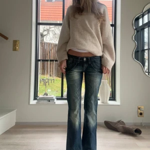 Low waist utsvängda jeans - Säljer ett par snygga blå bootcut jeans i bra skick. Jeansen är lågmidjade och har coola detaljer med knappar och fickor. Jeansen är tillräckligt långa för mig som är 175cm lång men kan definitivt också passa de som är kortare än så🥰Skulle säga att storleken på jeansen är lite mindre än av det står. Det är bara att skriva om man skulle vilja ha specifika mått eller fler bilder!