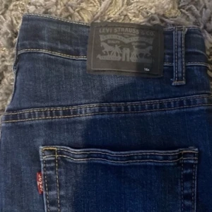 Levi's 511 Slim Jeans - Snygga Levi's 511 Slim jeans i en klassisk blå färg. De har en slim passform och är perfekta för en stilren look. Jeansens design inkluderar den ikoniska Levi's-lappen och den röda etiketten vid bakfickan.