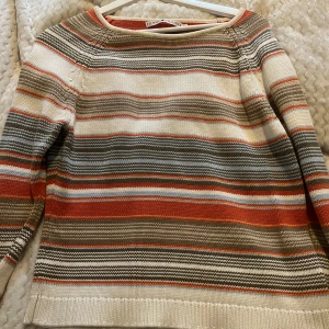 Randig tröja från Tommy Hilfiger - Säljer en snygg randig tröja från Tommy Hilfiger i jordnära färger som beige, orange och grå. Tröjan är stickad och har långa ärmar med ribbade muddar. Perfekt för en avslappnad stil. 🧡Står storlek M men jag tycker den passar mer S