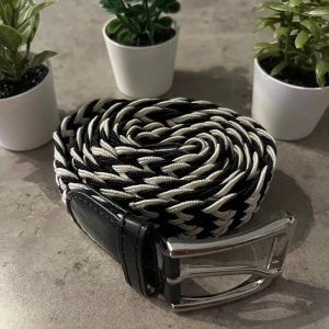 Flätat bälte  - Säljer ett stilrent mörkblått och vitt flätat bälte. Perfekt touch till din outfit. Bältet är justerbart och passar de flesta storlekar.