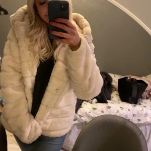 Vit pälsjacka med huva - Säljer en supermjuk och fluffig vit pälsjacka med luva. Köpt på secondhand för 400 och använd ca2 gånger jättefint skick storlek l men passar mig som har storlek s