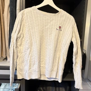 Vit stickad tröja från Bondelid - Säljer en stilren vit stickad tröja från Bondelid med kabelstickat mönster. Tröjan har långa ärmar och en rund halsringning. Perfekt för kyligare dagar.