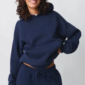 Mörkblå hoodie - Säljer en mysig mörkblå hoodie med en klassisk design. Den har en stor ficka framtill och en bekväm huva. Perfekt för en avslappnad stil.