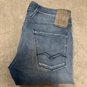 Replay jeans - Snygga blå jeans från Replay Hyperflex med en klassisk femficksdesign. De har en diskret tvättad look och en bekväm passform. Perfekta för en avslappnad stil.. w28/l32