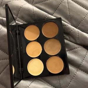 Concealerpalett från Sleek MakeUp - Snygg concealerpalett från Sleek MakeUp med sex olika nyanser. Perfekt för att täcka ojämnheter och skapa en jämn hudton. Kompakt och lätt att ta med i väskan.