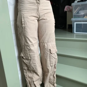 Beige cargobyxor - Säljer ett par beige cargobyxor med flera praktiska fickor och en avslappnad passform. Byxorna har en low waist och är perfekta för en casual look.