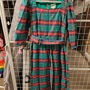 Randig klänning från Joanie - Säljer en superfin randig klänning från Joanie storlek 40. Klänningen har en härlig mix av färger som grön, rosa och blå med ett bälte i midjan för en snygg passform. Den har trekvartsärmar och en bekväm, normal passning. Perfekt för vår och sommar!