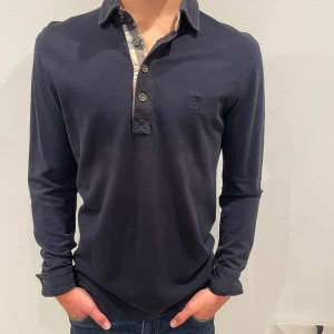 Burberry piké  - Säljer denna snygga långärmade mörkblåa burberry piké super snygg och är i bra skick. Tveka inte med att höra av er om fler bilder eller mer information! 