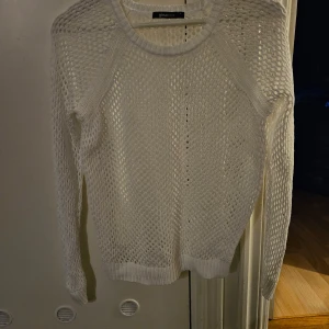 Vit stickad tröja från Gina Tricot -  Nytt Säljer en superfin vit  tröja från Gina Tricot. Den har ett snyggt nätmönster som gör den perfekt för lager-på-lager-stil. Tröjan är långärmad och har en rund halsringning. Perfekt för både vår, höst  och sommar! Mer som en strl s-m