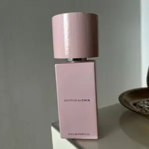 Senteur Eau de Parfum från CAIA. Flaskan är ljusrosa med en fyrkantig form och har ett matchande rosa lock. Se bild 2 för hur mycket det är kvar i flaskan. 