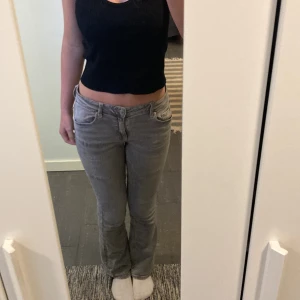 Grå jeansbyxor - Säljer ett par snygga grå jeansbyxor. De är bootcut och har en lågmidjad passform som sitter perfekt. 