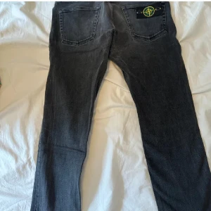 Grå jeans Stone Island - Snygga grå jeans från Stone Island med klassisk femficksdesign och knappgylf. Byxorna har Stone Island-märket på bakfickan. Köpte dessa från annan säljare här på plick, bilderna är därför lånade. Men de passade nämligen inte, så behöver tyvärr tyvärr sälja dem vidare. Tidigare säljare skrev att byxorna var nya utan prislapp.